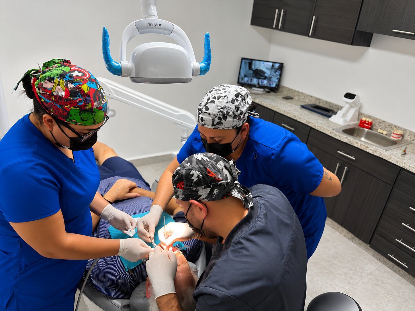 Dr. Candanosa and his team performing a dental procedure in their modern clinic